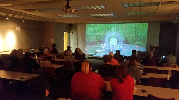 Students watch a video in a Memorial Hall classroom