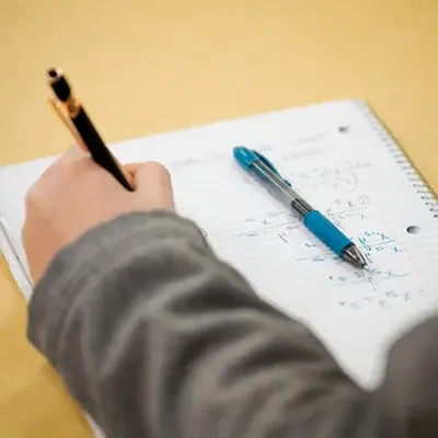 一个学生在笔记本上做数学的特写