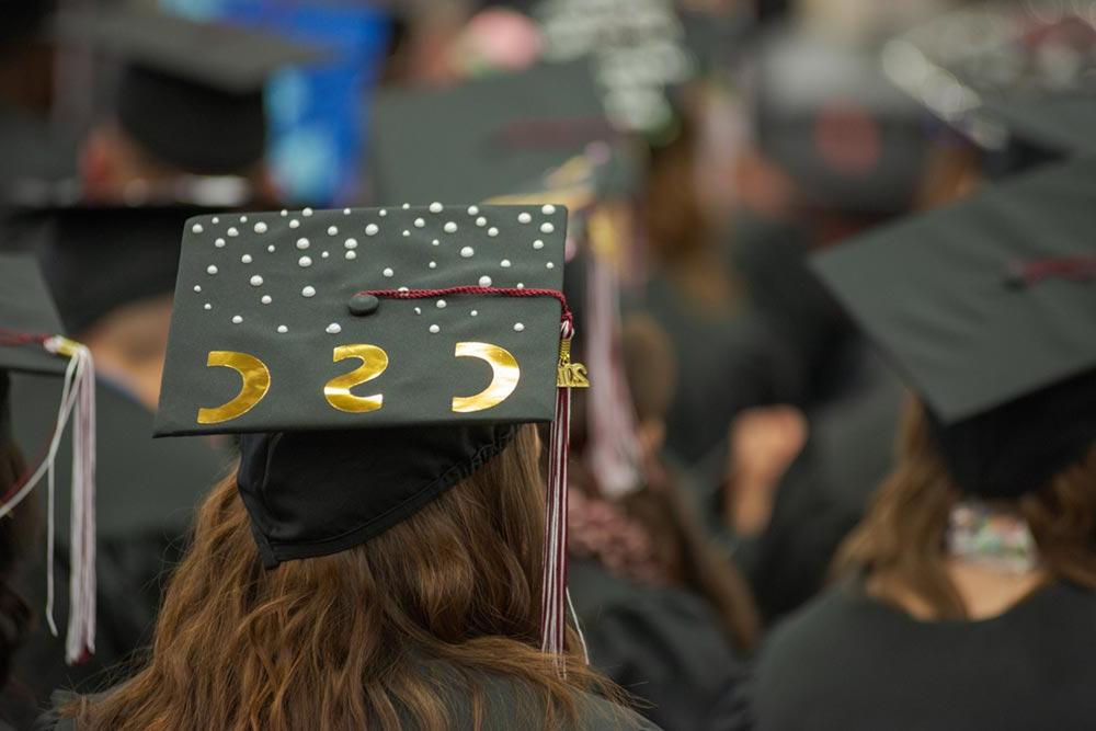 学生在毕业典礼上戴着一顶饰有CSC字样的帽子